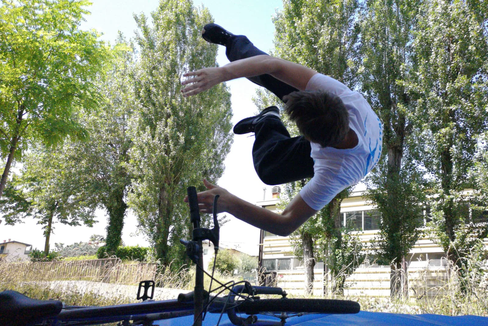 Un atleta esegue una figura acrobatica sopra una bicicletta